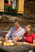 Couple eating a snack at Lammersdorfer hut 1650 m, Lammersdorf near Millstatt, Carinthia, Austria