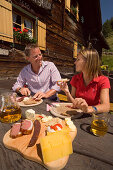 Couple eating a snack at Lammersdorf Hut, Lammersdorf near Millstatt, Carinthia, Austria