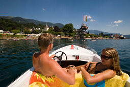 Couple on a boat trip on Millstätter See (deepest lake of Carinthia), view to the Strandbad, Millstatt, Carinthia, Austria