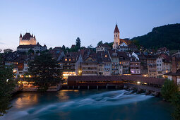 Blick über der Aare und Schleuse Richtung Schloss Thun und Stadt, im Abendlicht, Thun ist die grösste Garnisonsstadt der Schweizer Armee, Berner Oberland, Kanton Bern, Schweiz