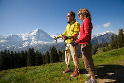Couple enjoying the view over Bernese Alps, view to Eiger North Face 3970 m, Bussalp 1800 m, Grindelwald, Bernese Oberland, Canton of Bern, Switzerland