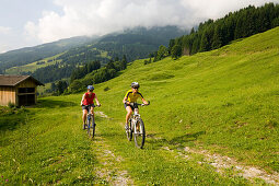 Two women riding mountain bikes, Amoseralm, Dorfgastein, Gastein Valley, Salzburg, Austria