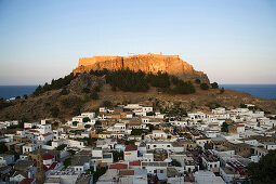 View over houses to hill with Acropolis, Lindos, Rhodes, Greece