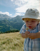 Boy with dandelion clock, Simmental vallley, Bernese Alpls, Canton of Bern, Switzerland