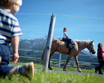 Mädchen sitzt auf einem Pferd, Mutter hält die Leine, Leogang, Salzburg, Österreich