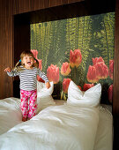 Girl jumping on a bed, Hotel Room, Spa Hotel Seehotel Neuklostersee, Mecklenburg - Western Pomerania, Germany