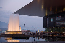 Illuminated fountain and KKL, culture and congress centre of Lucerne at Europaplatz in the evening, Lucerne, Canton of Lucerne, Switzerland