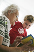 Oma und Kind lesen Buch, Kind, Familie, Generationen