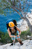 Junge Frau beim Klettern, hält sich an einer Kette, Il Sentiero Selvaggio Blu, Golfo di Orosei, Sardinien, Italien, MR