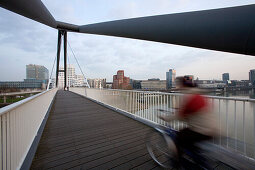 Cyclist on the footbridge at the Media Harbour in Düsseldorf, state capital of NRW, North-Rhine-Westphalia, Germany