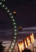 Big wheel and illuminated sign at night, Wiener Prater, Vienna, Austria