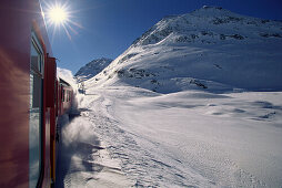 Rhätische Bahn fährt durchs winterliche Engadin, Kanton Graubünden, Schweiz
