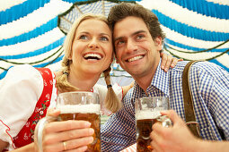 Lachendes Paar mit Maß Bier im Bierzelt