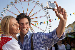 Mid adult couple photographing themselves with a digital camera