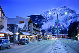 Banff Avenue im Morgenlicht mit Cascade Mountain im Hintergrund, Schnee, Winter, Alberta, Kanada