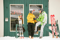 Zwei Skifahrer trinken Bier vor dem T-Bar Pub, Castle Mountain Skigebiet, Alberta, Kanada