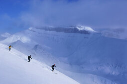 Three skiers in deep snow, Lake Louise, Alberta, Canada