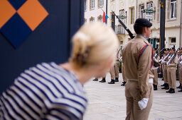 Young woman observing changing of the guard at Grand Ducal Palace, Luxembourg, Luxembourg