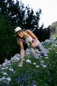 Young woman picking flowers, Icking, Bavaria, Germany