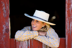Cowgirl schaut aus Scheunenfenster, Wilder Westen, Oregon, USA