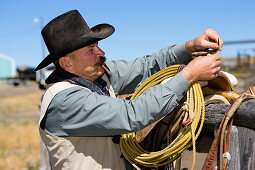 cowboy preparing saddle, wildwest, Oregon, USA