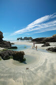 Hiking on Wharariki Beach, tidal pools, low tide, near Puponga, northwestern coast of South Island, New Zealand