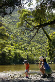 Mother with children at riverside, hiking in Punakaiki National Park, north of Hokitika, Westcoast, South Island, New Zealand