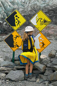 Girl watching warning signs, hiking at Franz Josef Glacier, Westland National Park, Westcoast, South Island, New Zealand