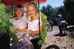 Zwei Kinder, Mädchen in einer Kutsche mit Weinlaub, Dorffest, Glen Ellen, Sonoma Valley, Kalifornien, USA