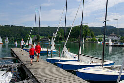 zwei Jungen auf Steg mit Segelbooten, Mattsee, Salzkammergut, Salzburg, Österreich