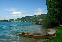 rowing boat at shore of lake Schliersee, village of Schliersee in background, Upper Bavaria, Bavaria, Germany