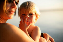 Mutter und Sohn am Seeufer vom Starnberger See, Junge mit Finger in der Nase, Ammerland, Bayern, Deutschland