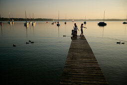 Children on jetty at Lake Woerthsee, Bavaria, Germany, MR