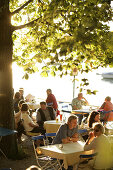 Guests sitting in a beer garden, Restaurant Woerl, Lake Woerthsee, Bavaria, Germany