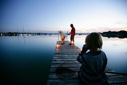 Jungen auf einem Steg am Wörthsee, Walchstadt, Bayern, Deutschland, MR