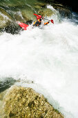 Man paddling through whitewater, kayak weekend for beginners on the Mangfall river, Upper Bavaria, Germany