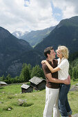 Junges Paar umarmt sich auf einer Alm, Heiligenblut, Nationalpark Hohe Tauern, Kärnten, Österreich