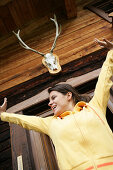 Woman stretching in front of alp lodge, Heiligenblut, Hohe Tauern National Park, Carinthia, Austria