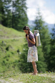 Woman carrying a milk can, Heiligenblut, Hohe Tauern National Park, Carinthia, Austria