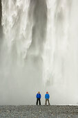 Two men stood in front of a waterfall, Iceland