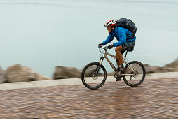 Mountain biker riding along Adriatic Sea coastline, Trieste, Friuli-Venezia Giulia, Italy