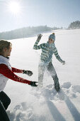 Zwei Frauen machen eine Schneeballschlacht, Steiermark, Österreich