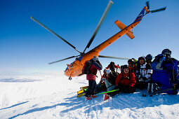 Gruppe Skifahrer auf einem Berg, Helikopter im Hintergrund, Heliskiing in Kamtschatka, Sibirien, Russland