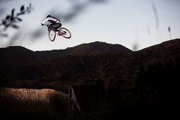 Young man jumping with a mountainbike, Oberammergau, Bavaria, Germany