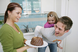 Young family with a chocolate cake in a domestic kitchen, Munich, Germany
