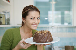 Junge Frau hält einen Schokoladenkuchen, München, Deutschland