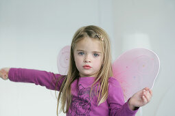 Girl (3-4 years) wearing butterfly wings holding wand, Munich, Germany