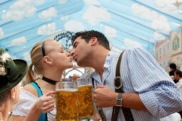 Junges Paar küsst sich auf dem Oktoberfest, München, Bayern, Deutschland