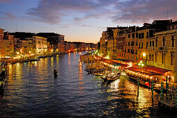 Canal Grande mit beleuchteten Häusern und Restaurants in der Abenddämmerung, Venedig, Venezien, Italien