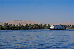 cruise ship on the Nile and palm trees on the western bank, Luxor, Egypt, Africa